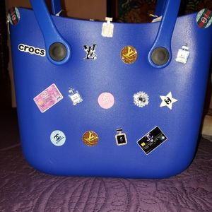 This blue Rare purse Uses multiple croc charms.
